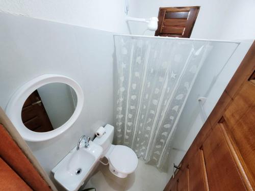La salle de bains est pourvue d'un lavabo, de toilettes et d'un miroir. dans l'établissement Pousada Maria do Ceú, à Guaramiranga