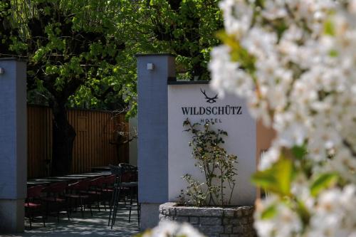a sign for a restaurant with tables and chairs at Aktivhotel Wildschütz in Altmünster