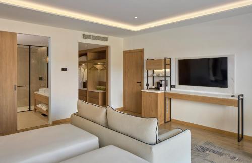 a living room with a couch and a television at Meliá Durrës Albania in Durrës