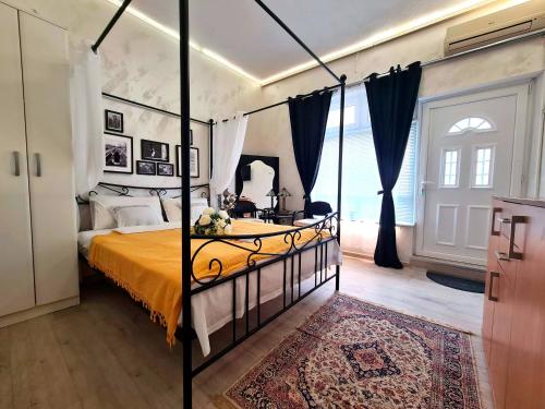 a bedroom with a canopy bed with a orange bedspread at Angelina apartmani. in Vračar (historical)