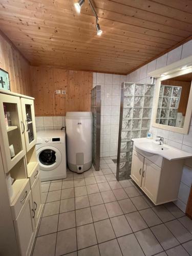 a bathroom with a washing machine and a sink at Naustplassen Rorbuer in Ballstad