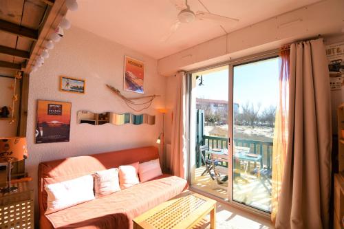 d'un salon avec un canapé et un balcon. dans l'établissement Dunes - Hossegor agréable studio en bordure de la plage sud d'hossegor, à Soorts-Hossegor