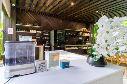 a table with a vase with white flowers on it at Tanaga CoLiving in Seminyak