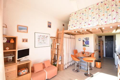 Cette chambre comprend une mezzanine avec un bureau et une table. dans l'établissement Dunes - Hossegor agréable studio en bordure de la plage sud d'hossegor, à Soorts-Hossegor