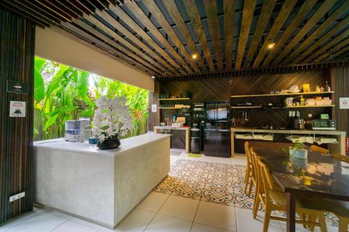 a kitchen with a counter and a table with chairs at Tanaga CoLiving in Seminyak