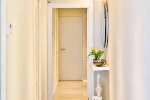 a hallway with a door and a plant on a table at MAGNÍFICO APARTAMENTO - primera línea de mar in Calafell