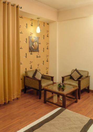 a living room with two chairs and a coffee table at Mg Regency in Baddi