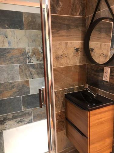 une salle de bain avec une douche, un lavabo et un miroir dans l'établissement Charmant T2 climatisé - Près des plages, à Narbonne