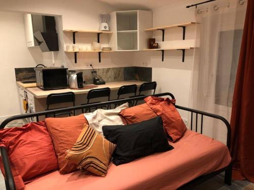 eine Couch mit Kissen darauf in einem Zimmer in der Unterkunft Charmant T2 climatisé - Près des plages in Narbonne