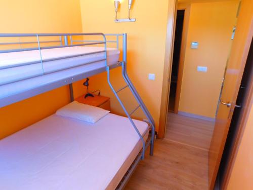 Cette chambre comprend 2 lits superposés et un couloir. dans l'établissement GMID IMMO A222 Gregal Piso 2 habitaciones, parking y piscina, à Roses