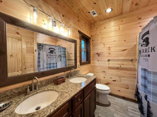 a log cabin bathroom with two sinks and a toilet at * * 4 Master Bedrooms, Views, Theater, Arcade, EVC in Gatlinburg