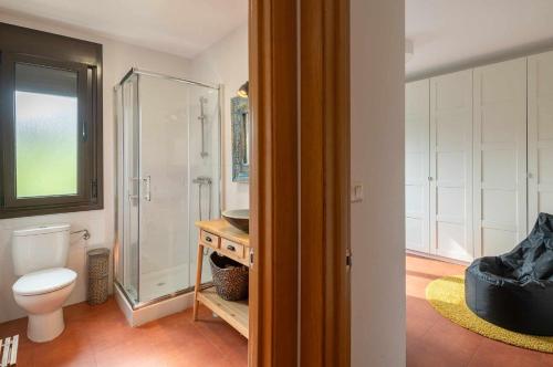 La salle de bains est pourvue de toilettes et d'une douche en verre. dans l'établissement Villa vacacional Taty, à Llanes