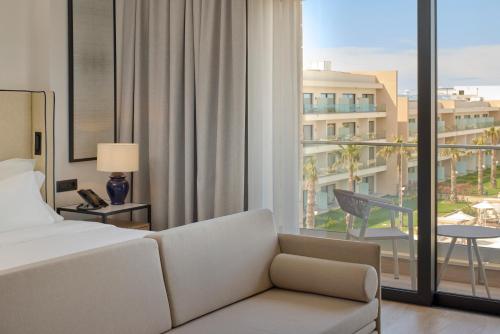 a hotel room with a couch and a large window at Meliá Durrës Albania in Durrës
