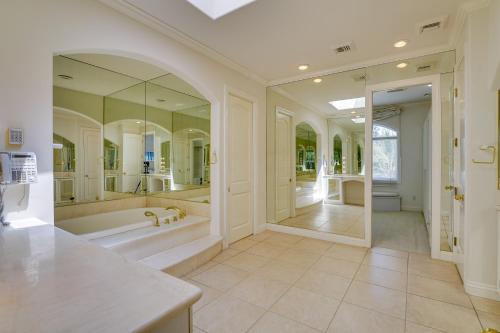 a large bathroom with a tub and a large mirror at Elegant Las Vegas Estate with Pool about Near Golf and Strip in Las Vegas