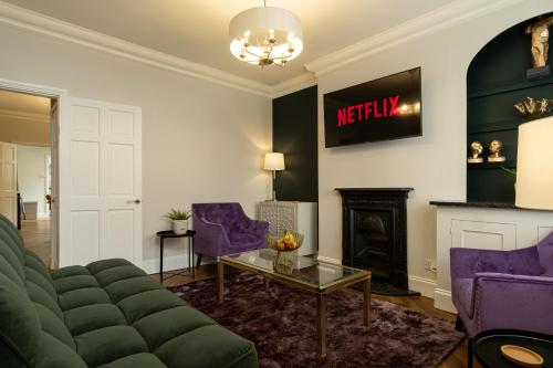 a living room with a couch and a fireplace at Ellistown Retreat in Hugglescote