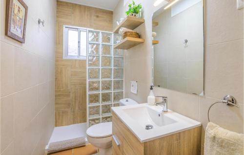 een badkamer met een wastafel, een toilet en een spiegel bij Stunning Home In Mijas With Swimming Pool in Mijas