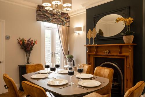 a dining room with a table and a fireplace at Ellistown Retreat in Hugglescote
