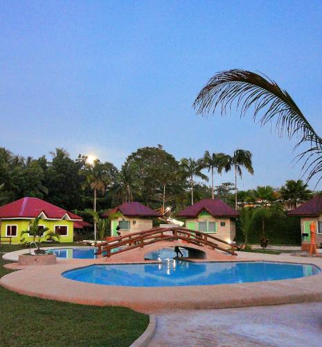 a bridge over a swimming pool in a resort at AGHAO MIDGREENS RESORT 