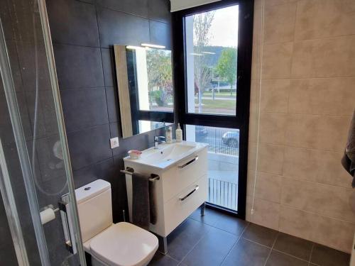 a bathroom with a toilet and a sink and a shower at Espectacular piso nuevo con piscina in Platja  d'Aro