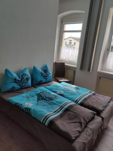 een bed met blauwe kussens in een kamer bij FeWo Bad Kösen Loreleypromenade in Bad Kösen