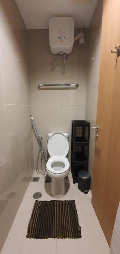 a bathroom with a toilet and a rug on the floor at TreeParkCity apartments by WinsHome in Tangerang