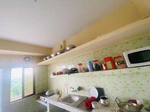 a kitchen with a sink and a microwave at private apartment in hill view tower in Sylhet
