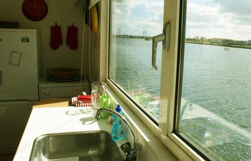 a sink and a window with a view of the water at Ecostay de IJsvogel in Kampen