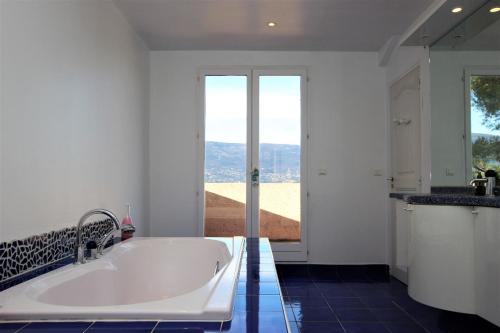 eine große weiße Badewanne im Bad mit Fenster in der Unterkunft HSUD0145-La manda in Colomars