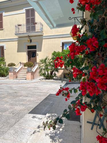un edificio con flores rojas frente a un edificio en La Villa, Tiburtina Valley, en Roma