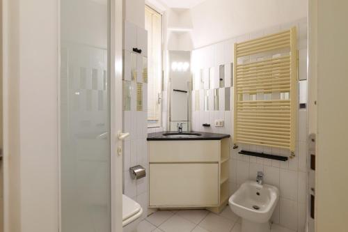 a white bathroom with a sink and a toilet at Elegant Terrace Suite in Milan