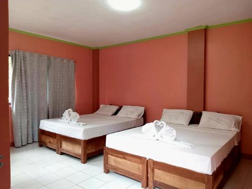 two beds in a room with red walls at AGHAO MIDGREENS RESORT 