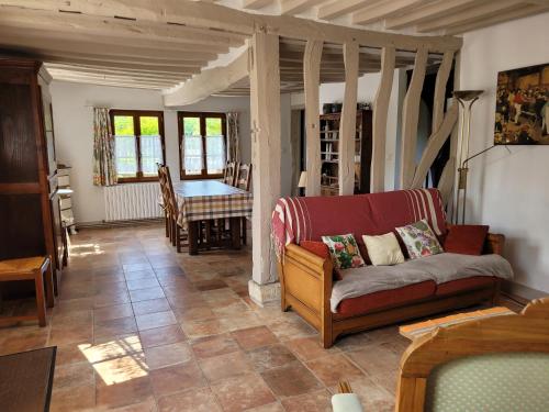 a living room with a couch and a table at La Porterie face à l'abbaye in Le Bec-Hellouin