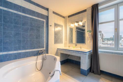 a bathroom with a tub and a sink and a mirror at EA ApartHotel Melantrich in Prague