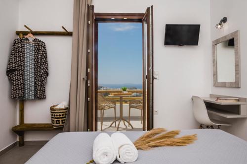 um quarto com uma cama e uma porta com uma varanda em Petros Studios & Suites em Naxos Chora