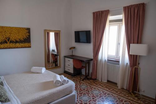 a bedroom with a bed and a desk and a window at Appartamento Natinguerra in Civitanova Marche