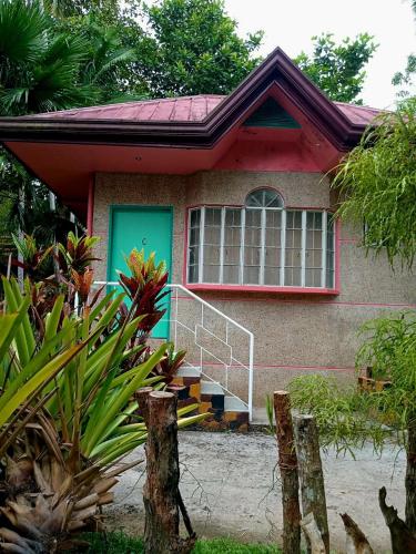 a house with a green door and stairs in front of it at AGHAO MIDGREENS RESORT 