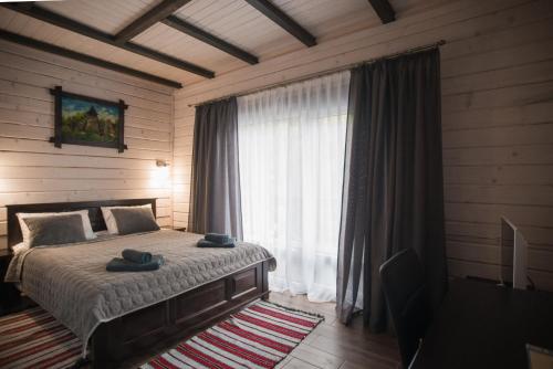 a bedroom with a bed and a large window at Chalet Carpat Dream in Synevyr