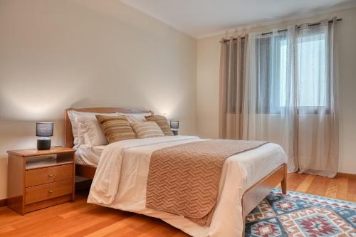 a bedroom with a large bed and a window at Baia Machico, a Home in Madeira in Machico