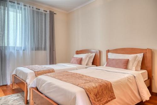 2 camas en una habitación con ventana en Baia Machico, a Home in Madeira, en Machico