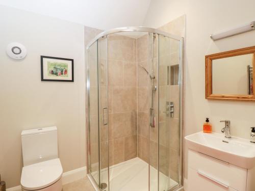 a bathroom with a shower and a toilet and a sink at The Cow Shed in Stroud