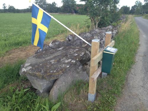 a flag sitting on a rock next to a road at Nordanå Gård in Strö