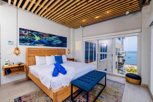 a bedroom with a bed and a large window at Fully Smart Studio Apartment Harbor View in Oranjestad