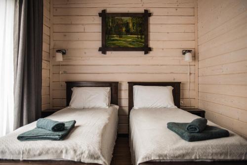 two beds in a room with towels on them at Chalet Carpat Dream in Synevyr