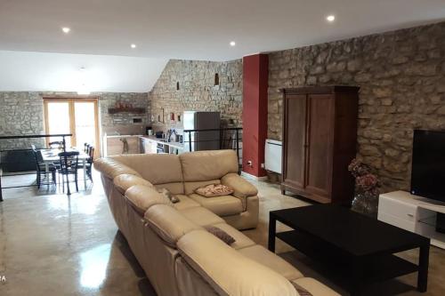 uma sala de estar com um sofá, uma mesa e uma cozinha em maison de charme avec jardin em Cousance