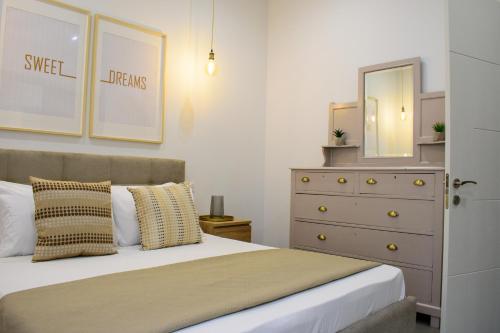 a bedroom with a bed with a dresser and a mirror at Casetta Pulis (Close to Airport & Valletta) in Tarxien