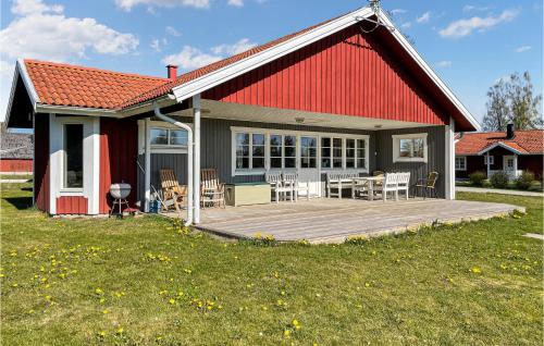 a red barn with a wooden deck in front of it at Amazing Home In Vittaryd With Kitchen in Kvänarp