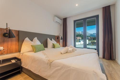 een slaapkamer met een groot bed en een groot raam bij Lux Ella Apartment With Shared Pool in Makarska
