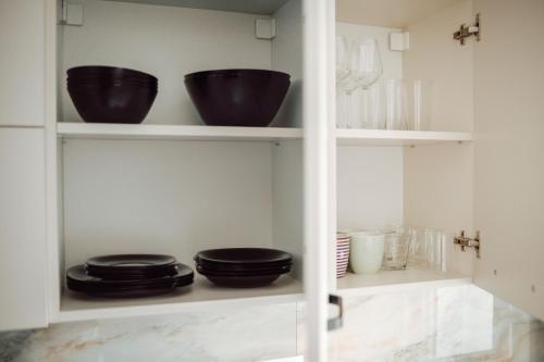 a kitchen with black bowls and plates on shelves at Adrian Home Delice in Ploieşti