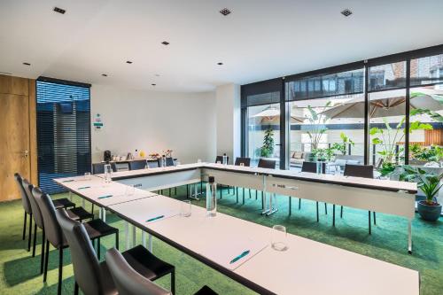 a restaurant with tables and chairs and a pool at Occidental Diagonal 414 in Barcelona