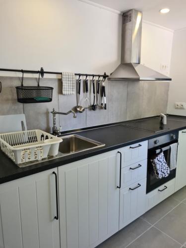 a kitchen with white cabinets and a sink at Greco Paradise Suites - ADULT ONLY in Nea Skioni